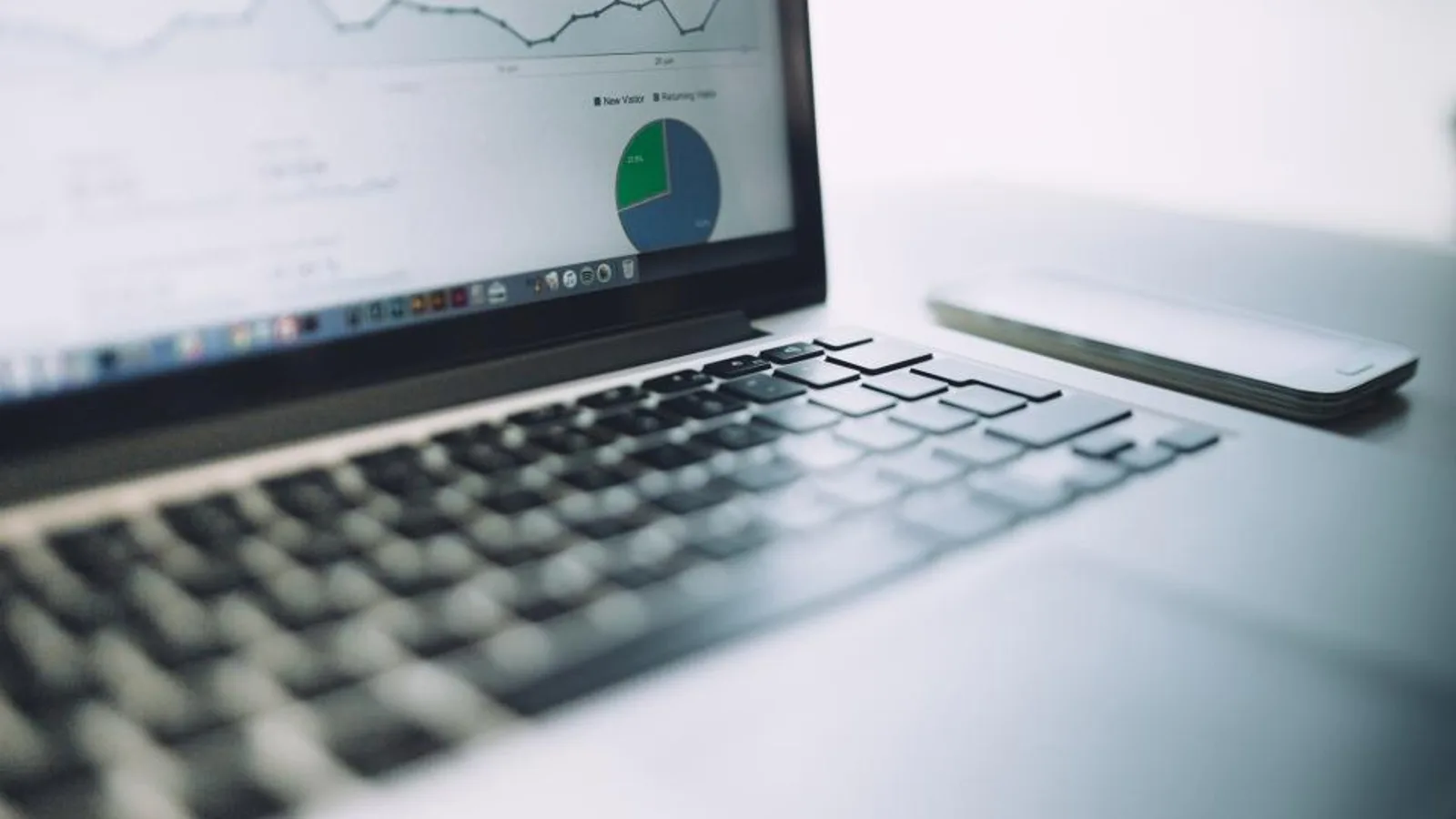A laptop showing a marketing analytics dashboard with charts.