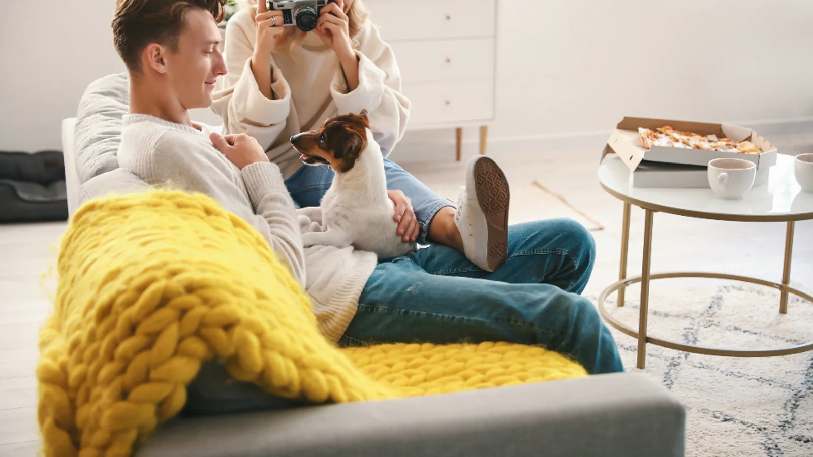 A couple photographing their living room with a camera.